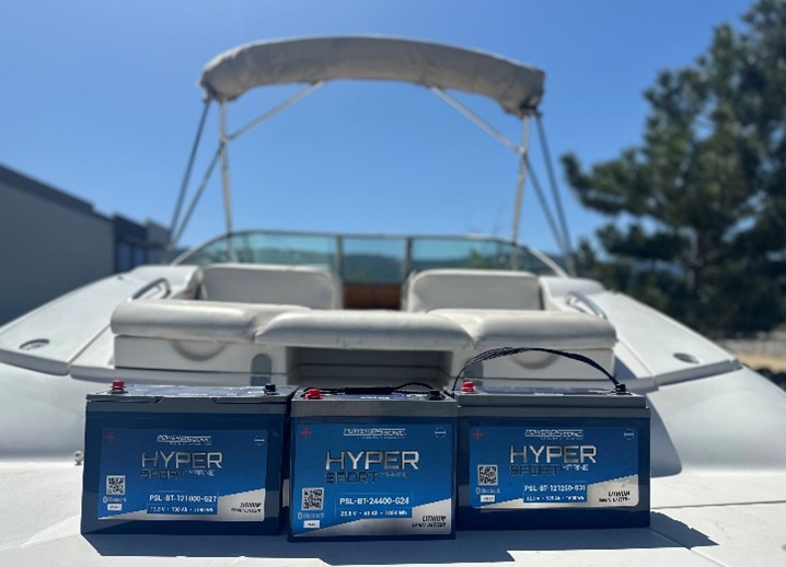 Three bright blue Power Sonic Marine Lithium batteries sit proudly on the back of a fishing boat, with clear blue sky in the background.